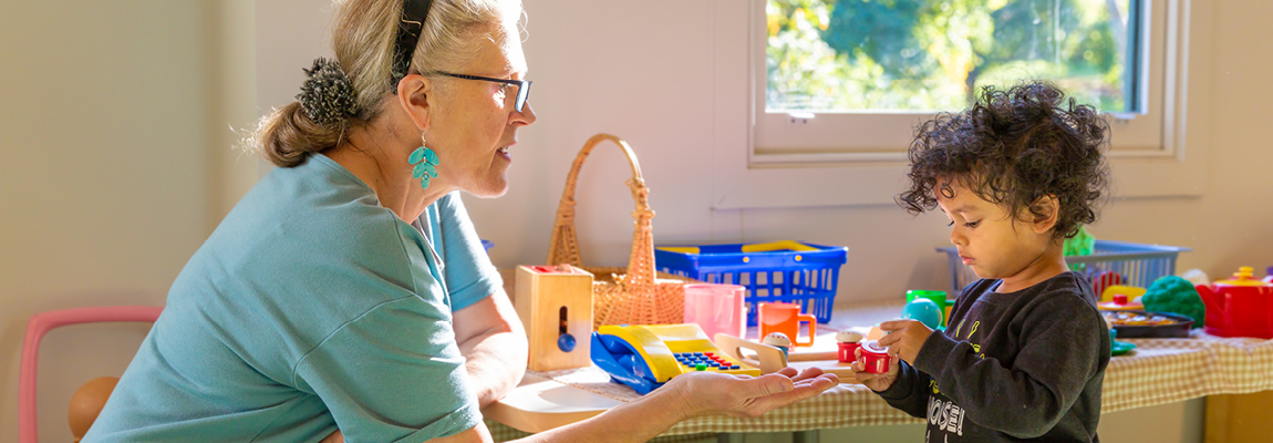 Older woman and child playing with Lego beside a window