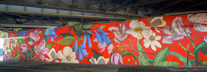 A vibrant mural of flowers on the wall of an underpass