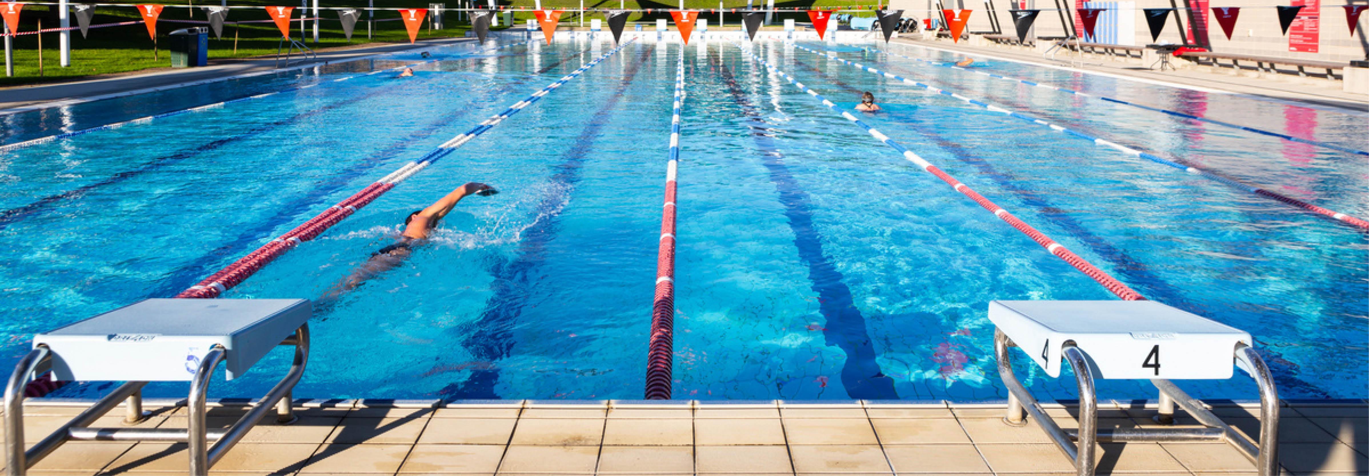 People swim laps in an outdoor pool