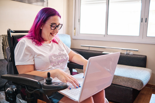 A person in a wheelchair using a laptop