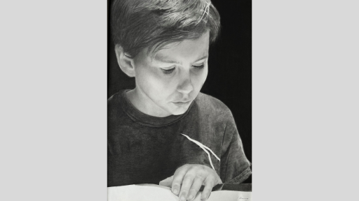 Boy looking down at an open book.