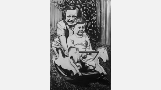 a toddler sitting in a rocker shaped like a horse, with an older child crouched behind and rocking the rocker