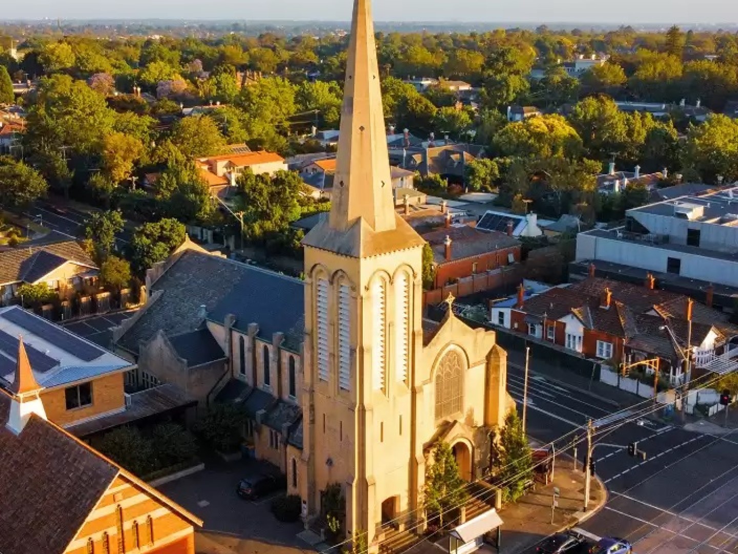 An aerial view of the spire of St Mark's Anglican Church in the setting sun