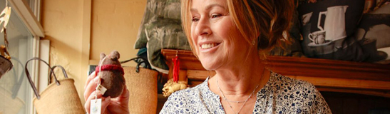 Woman in a shop holding a Christmas ornament