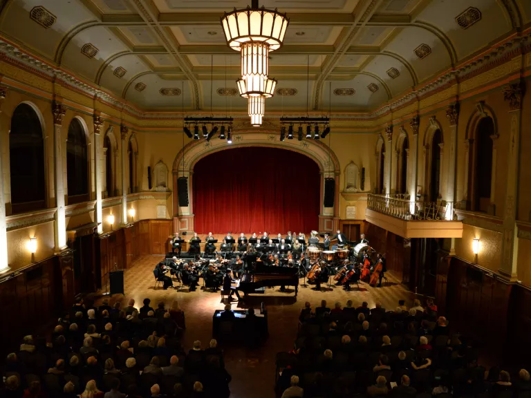 View from the balcony of the Main Hall at Hawthorn Arts Centre. Looking down on an audience and an orchestra.