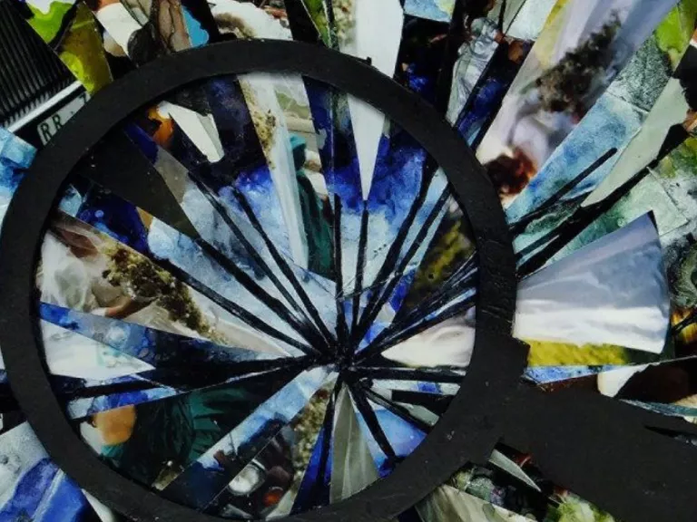 A collage of a shattered magnifying glass, made from photos and card. 