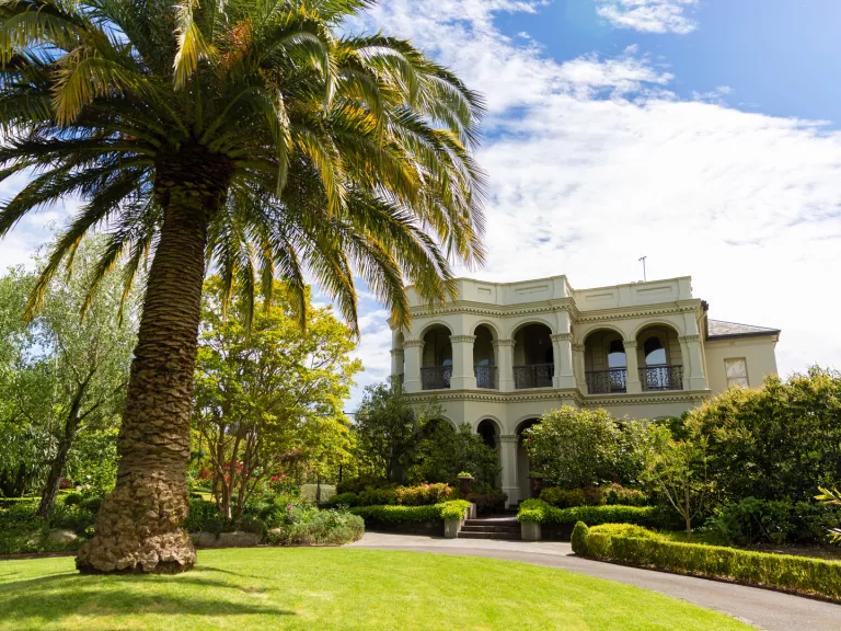 A heritage building in manicured gardens.