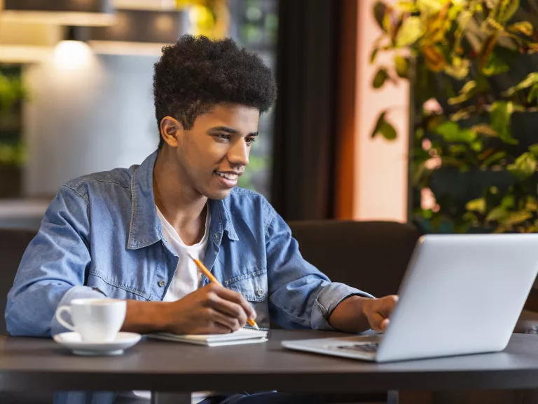 Man at computer with notepad