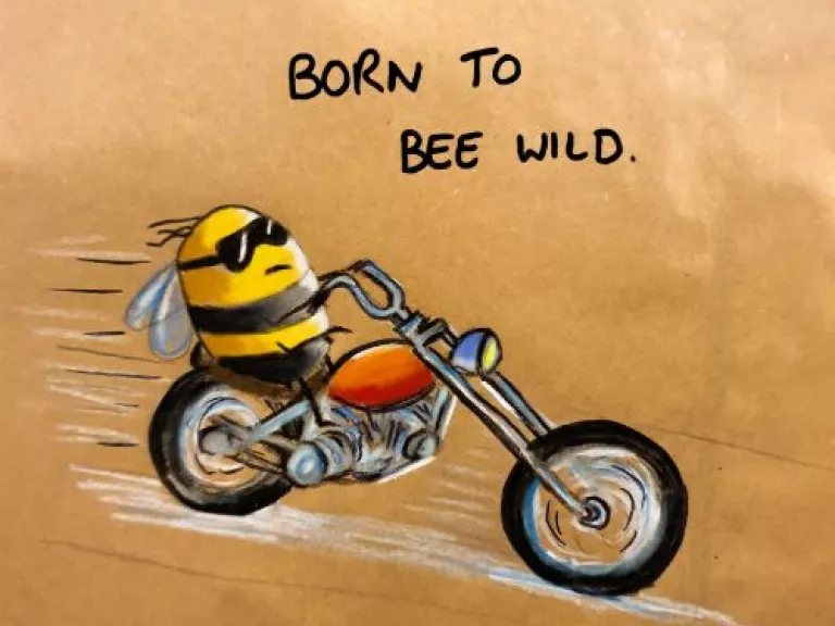 A drawing of a bee in sunglasses riding a motorcycle, with the text 'Born to bee wild' above it