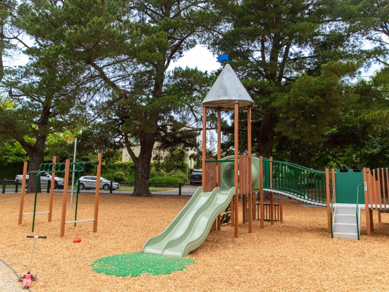 Playground showing a timber unit with slide, walkway and climbing stairs