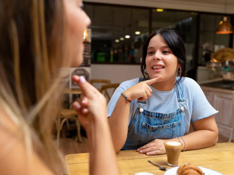 Two young women communication in sign language