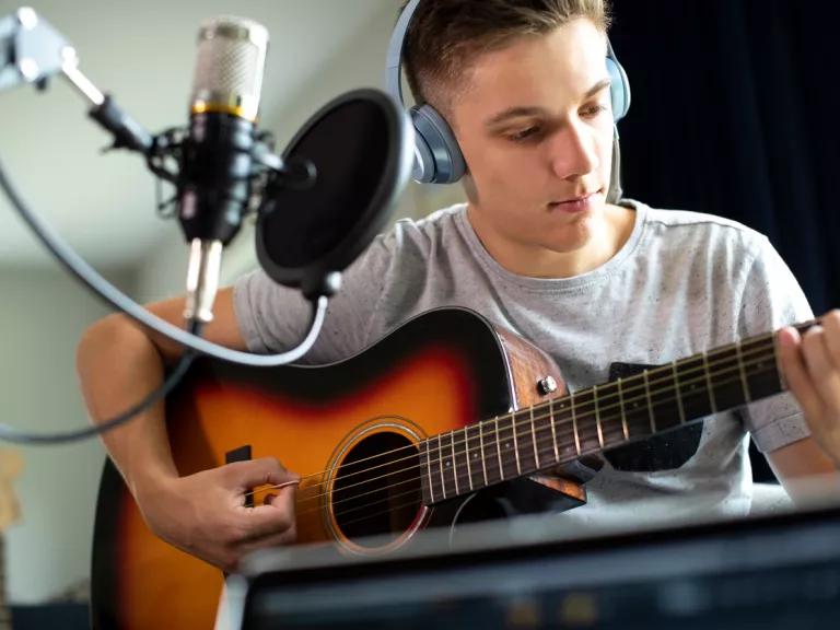 A young person playing the guitar