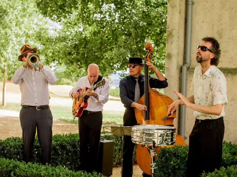 4 musicians, playing a trumpet, guitar, double bass and snare drum