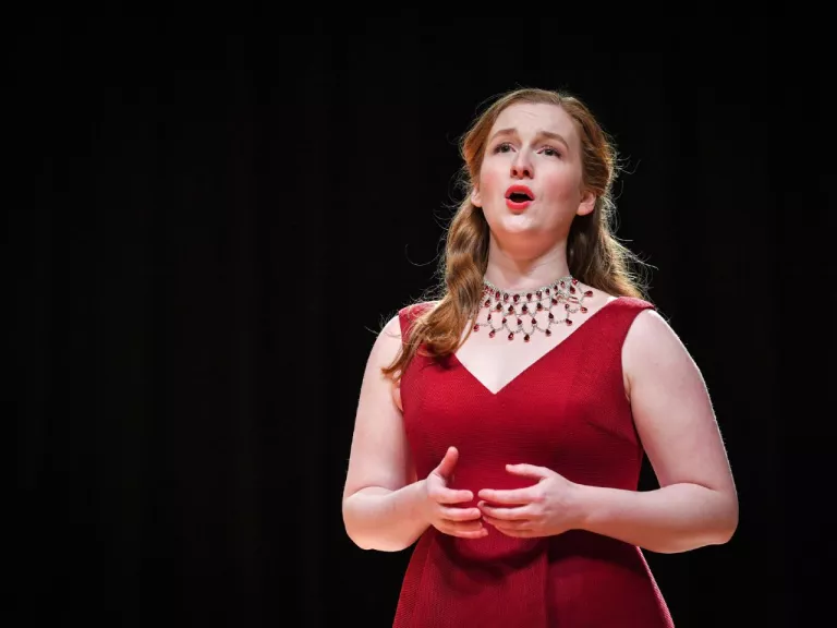 Woman in a red dress singing on stage