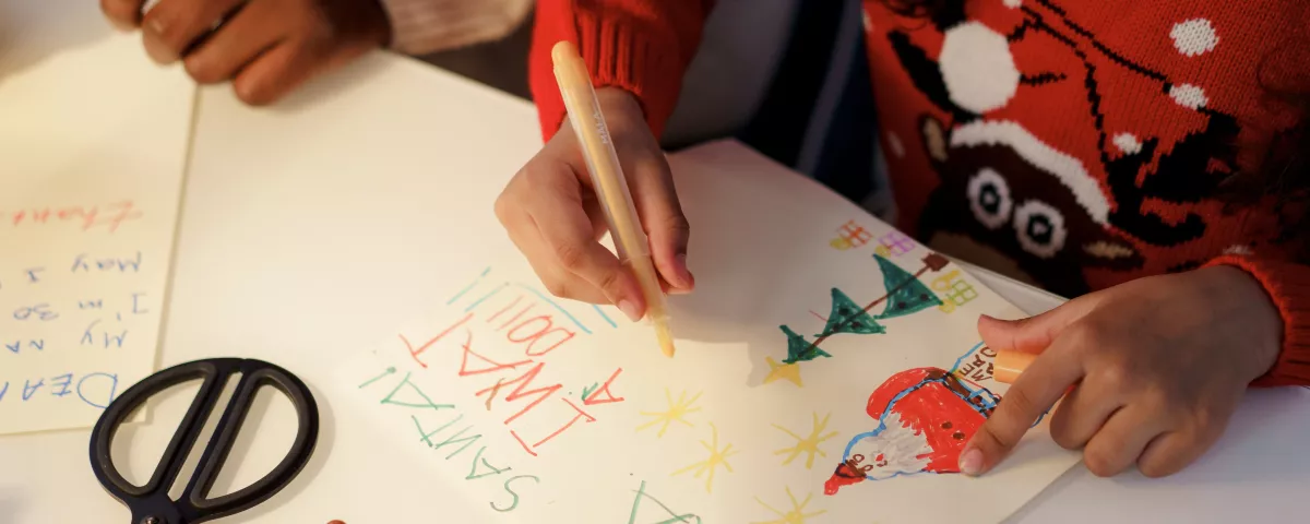 Two children making Christmas cards