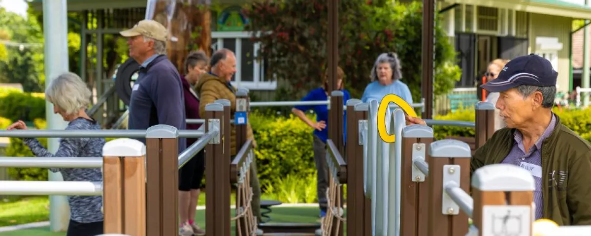 senior men and women using outdoor exercise equipment