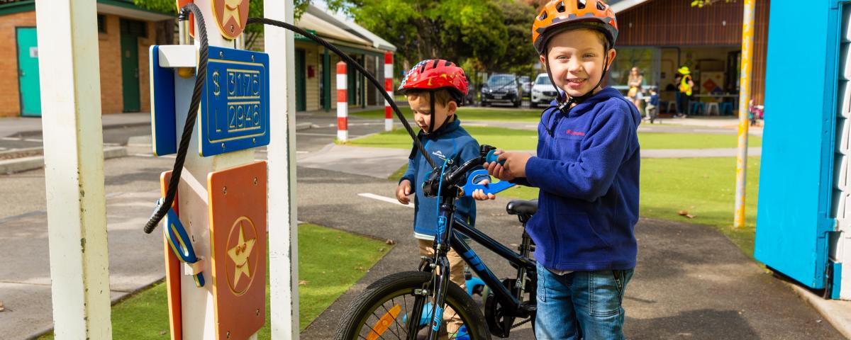 2 young children wearing helmets standing with their bikes at Kew Traffic School