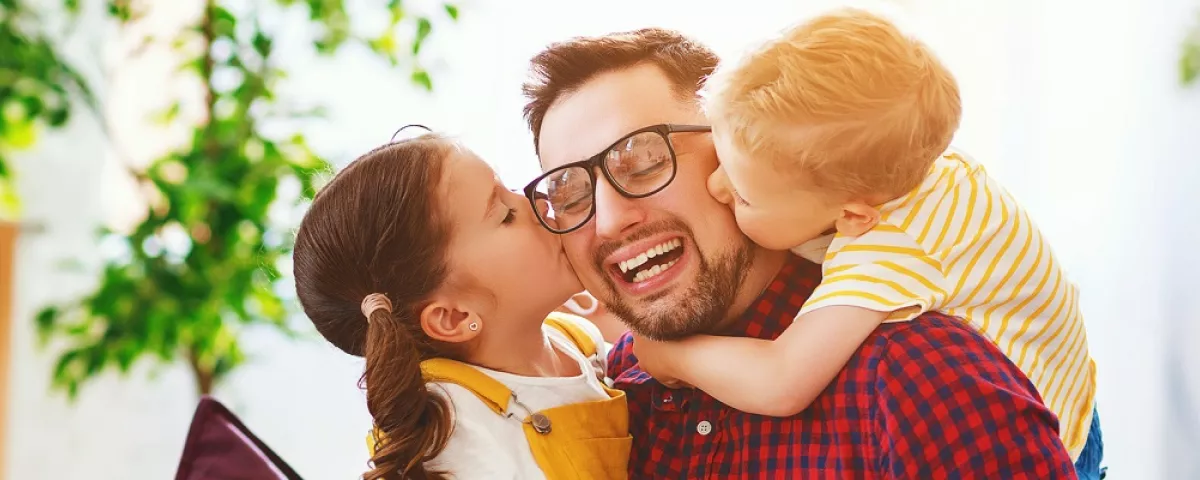 a bearded man gets a big hug from 2 small kids