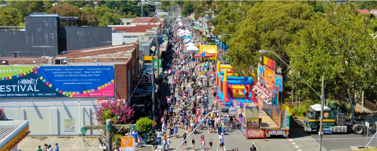 Overhead photo shows crowds of people on shop-lined street