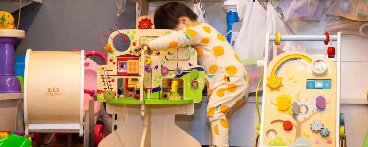 Small child plays with colourful wooden toy