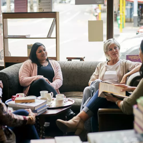 5 people sitting on couches holding books