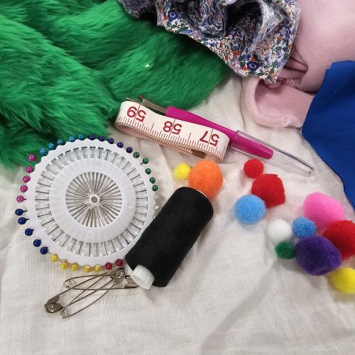 a tape measure, pins and other sewing notions on top of fake fur fabric