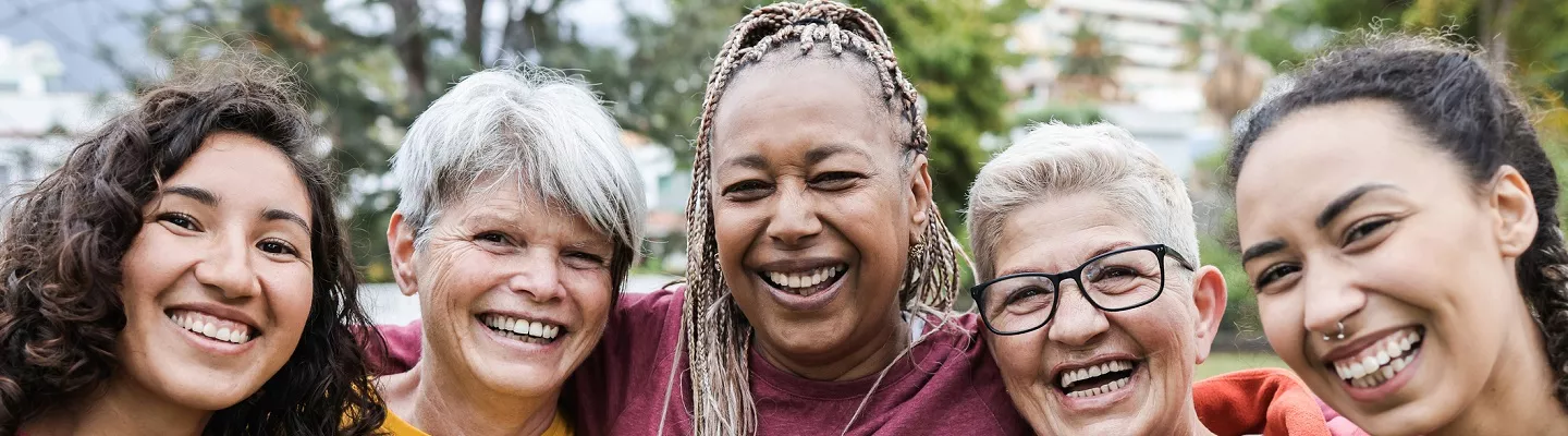 Five women standing together smiling