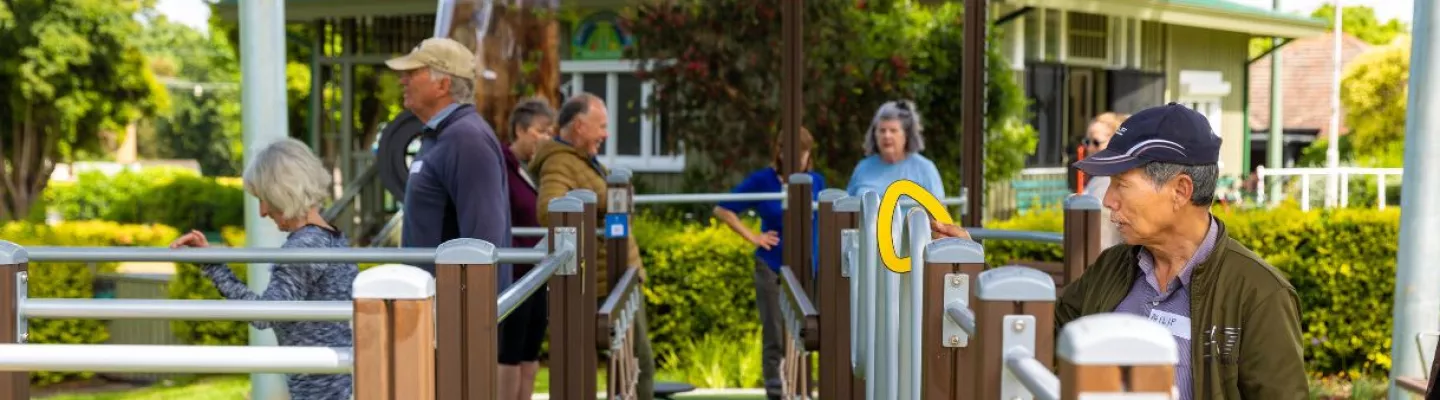 senior men and women using outdoor exercise equipment