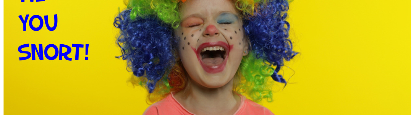 Young child with mouth wide open and eyes closed has coloured face paint and a rainbow wig on head. Child is wearing a pink tshirt with gold stars.