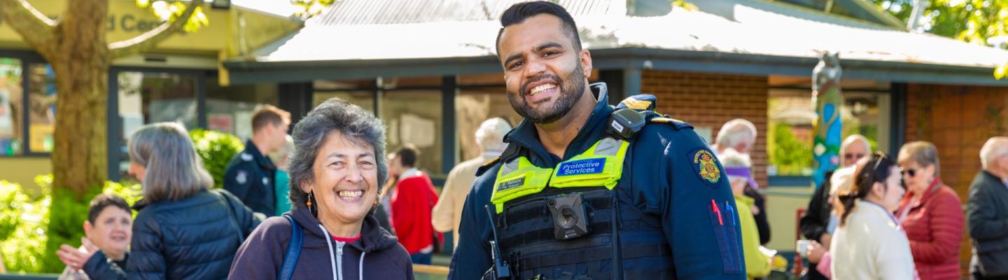 A police officer and an older adult standing together and smiling
