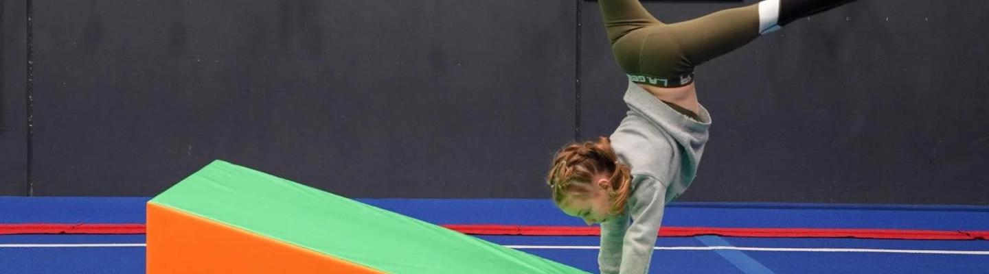 Child doing a handstand on a foam mat