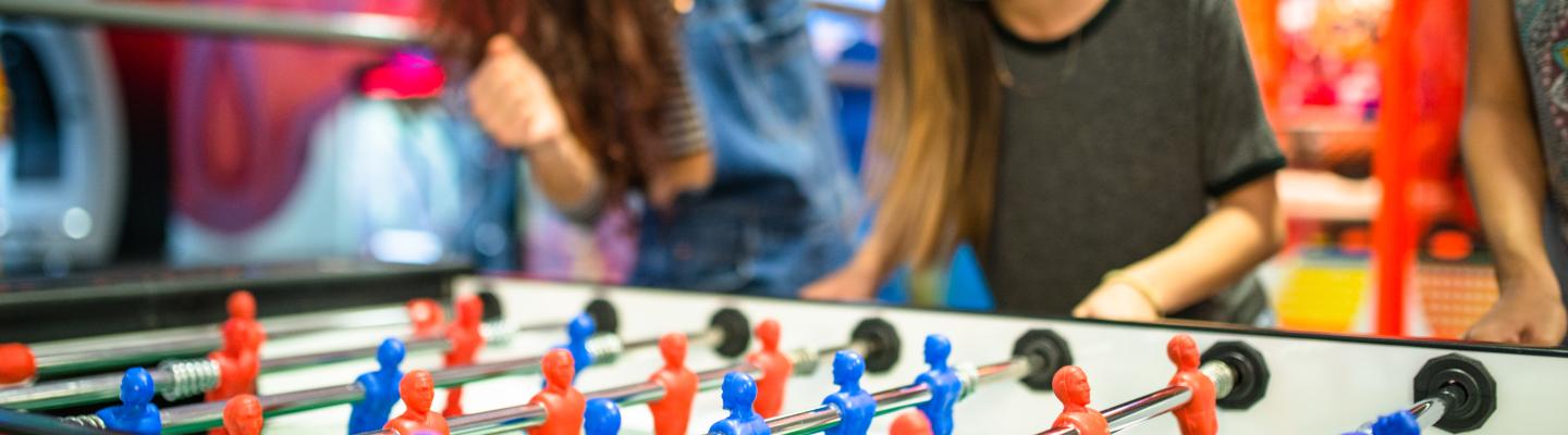 Teenage girls playing a tabletop football game