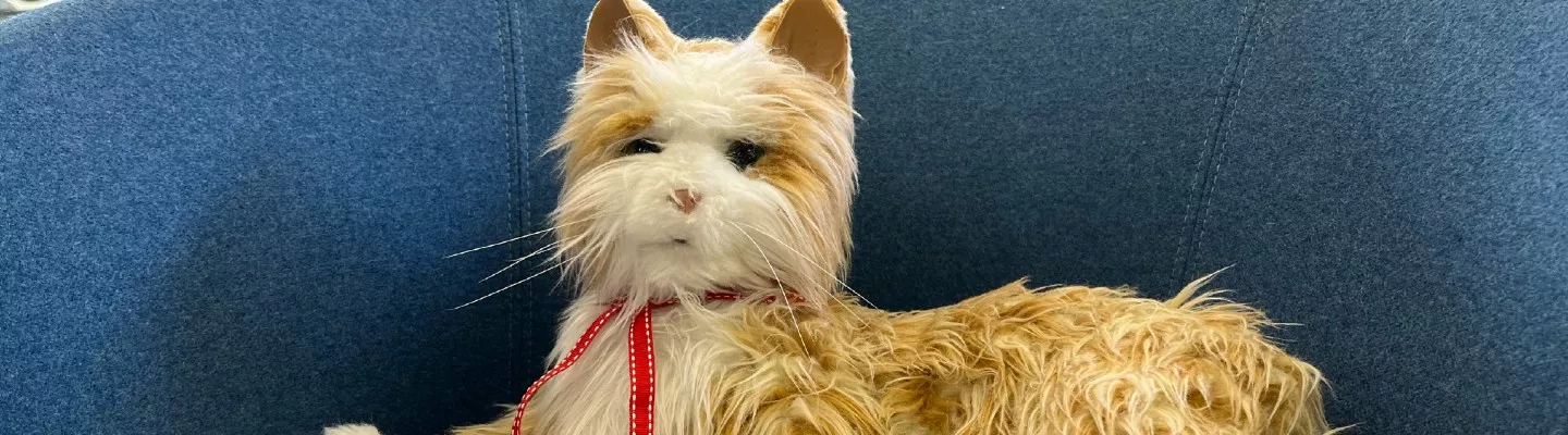 robotic cat with fake fur laying on a couch