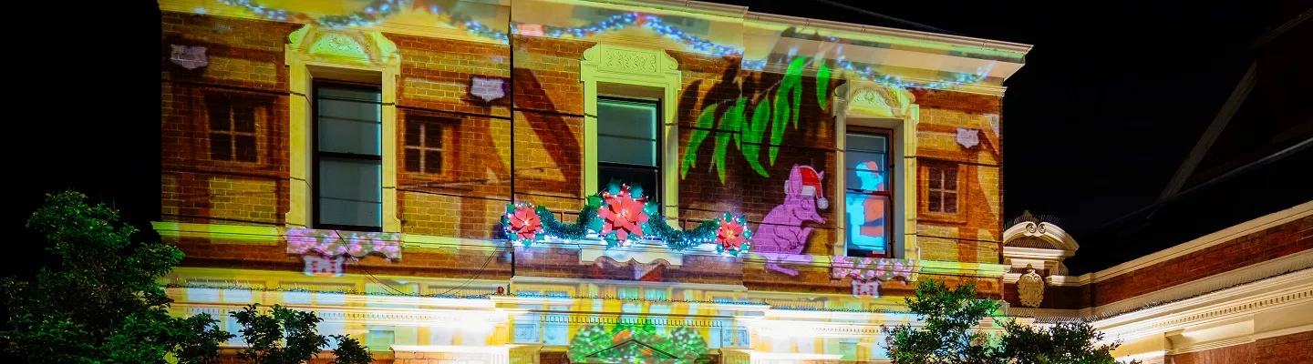 Exterior of Kew Court House lit up with projections of Christmas garlands