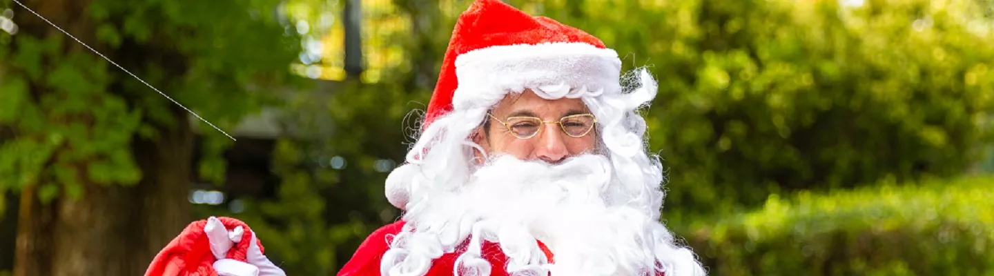 man with a big white beard, and a red hat edged with white