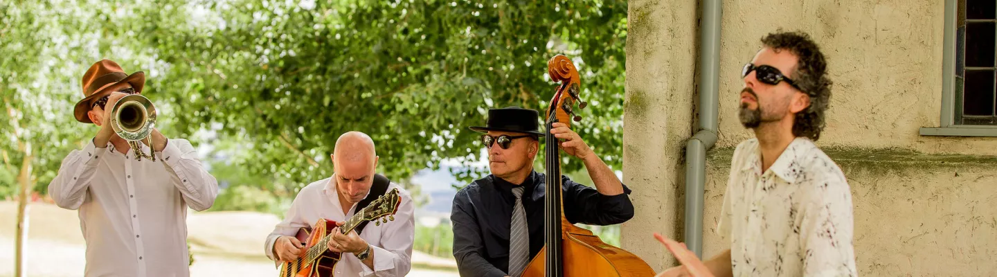 4 musicians, playing a trumpet, guitar, double bass and snare drum