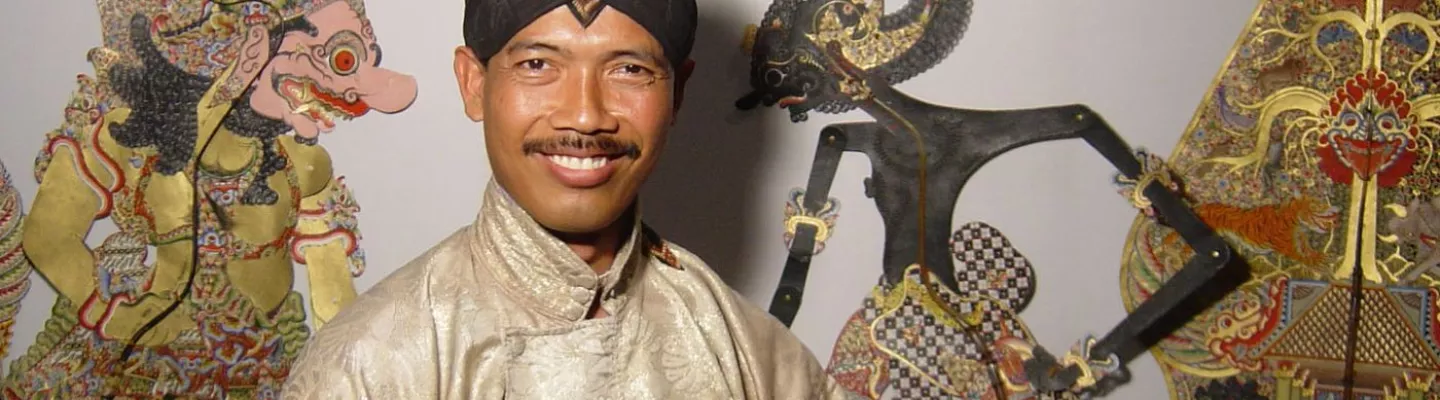 A smiling man in traditional Indonesian dress