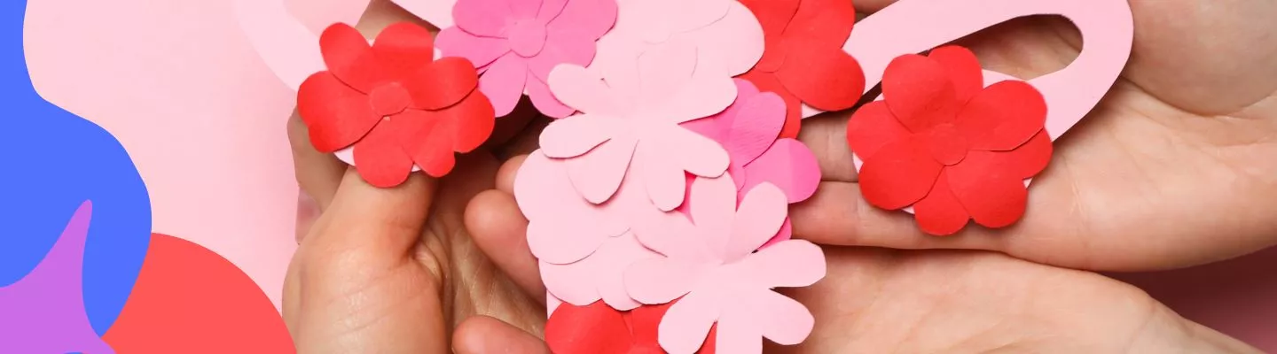 red and pink paper flowers resting on a womns hands