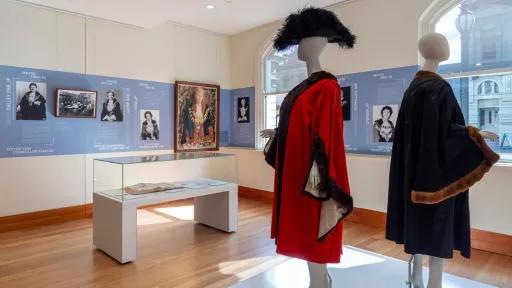 Two mannequins in mayoral robes in a gallery