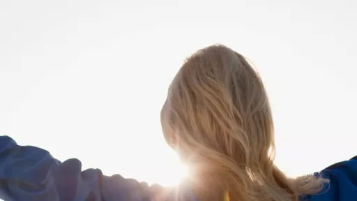 Woman with hands outstretched facing the sunshine