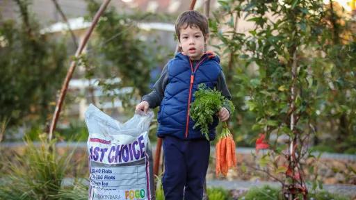 A boy standing next to FOGO compost