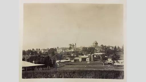 Photo of a landscape with some open fields alongside a populated area with buildings