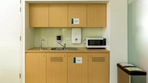 A kitchenette with microwave and sink