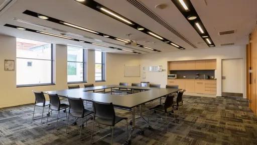 A carpeted room with U-shaped table 