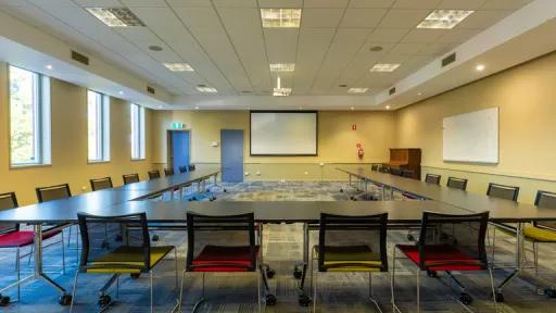 A large carpeted room with U-shaped table