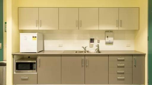 A kitchenette with boiling water unit next to the sink