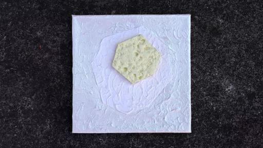 A ceramic artwork of a cream coloured hexagon on a pale background