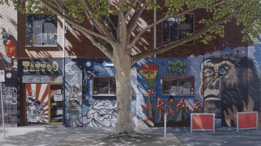 A street mural painted on the brick wall outside a tattoo shop, featuring the face of a monkey next to various images including mushrooms, graffitti style text, a person's face yelling, a blob with the ghana flag colours and the words 'chapter 1' inside, an astronaut in space and more