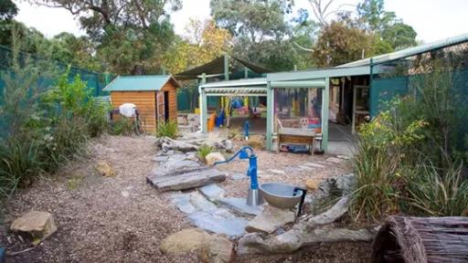 a cubbyhouse in a barkchip-covered nature playground