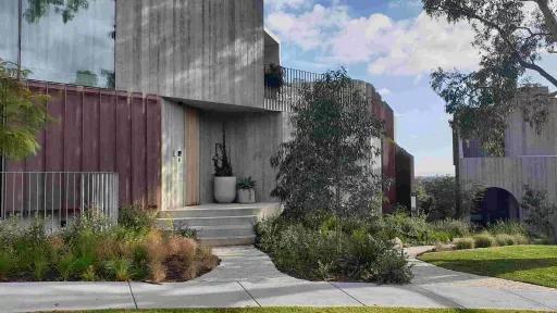 brutalist concrete building with no windows approached by a path with 4 stairs